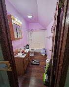 Compact bathroom with lavender walls and a wood vanity refreshed by T & A Contracting
