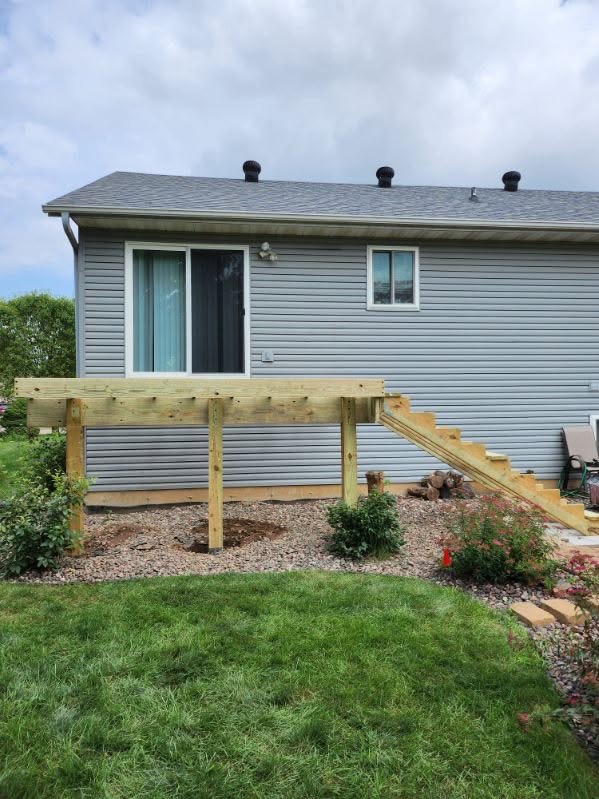 New deck framing attached to a home with a flashed ledger board by T & A Contracting