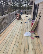 Fresh pressure-treated decking being installed over a rebuilt frame by T & A Contracting