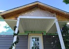 White soffit, fascia, and gable trim over a covered porch installed by T & A Contracting