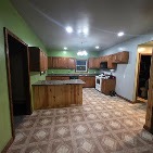Spacious kitchen with wood cabinetry and green walls before remodeling by T & A Contracting