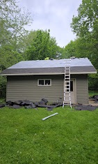 Green-sided home mid roof replacement with underlayment and ladder in place by T & A Contracting