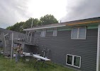 Back of a home with new gray siding and trim and an accessibility ramp by T & A Contracting