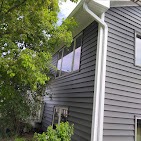 Two-story home with new gray lap siding and white corner trim by T & A Contracting