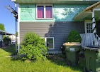 Home mid-project with old teal siding removed and new gray siding being installed by T & A Contracting